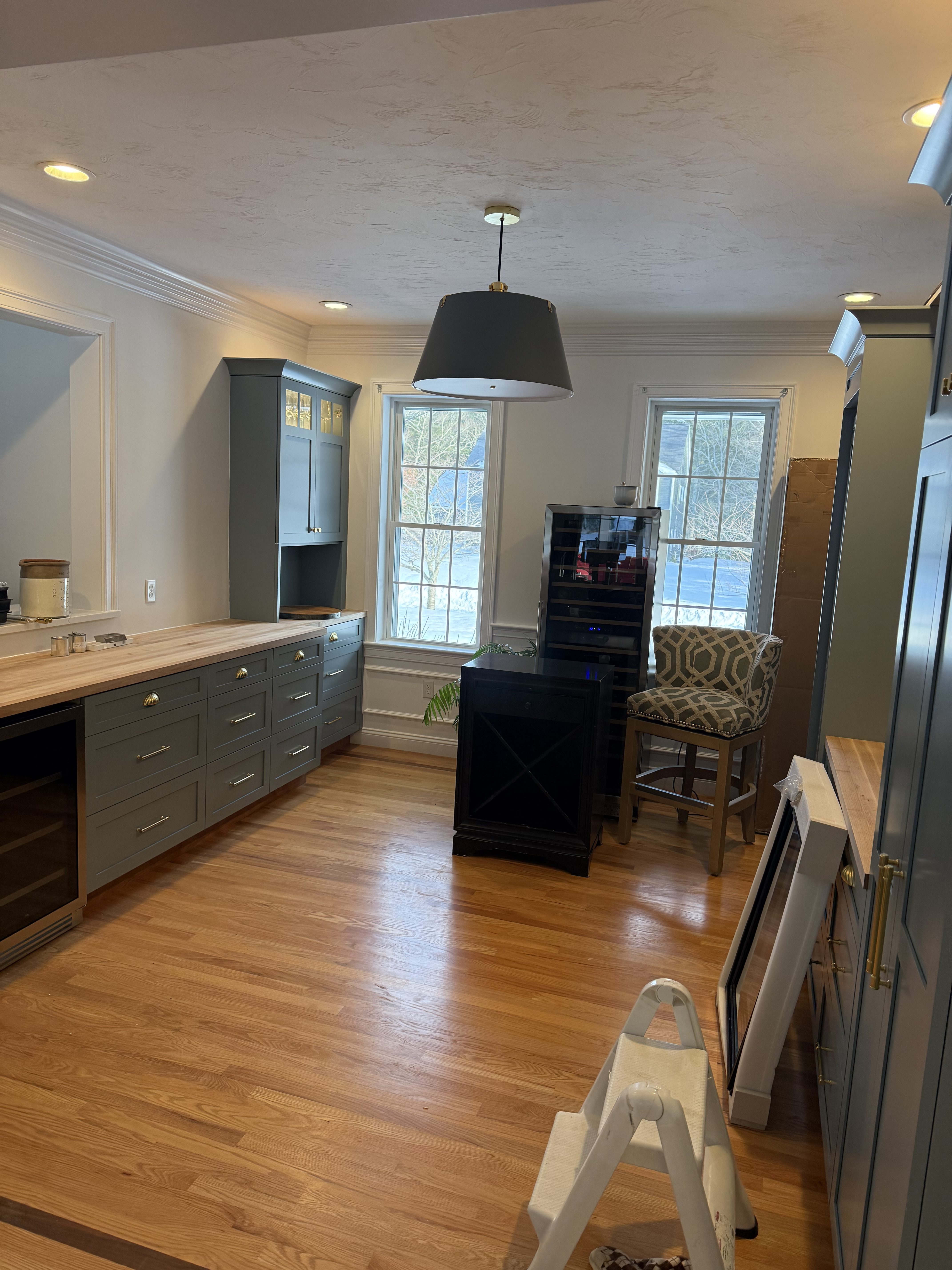 Kitchen mid-job with new recessed cans and a pendant fixture over the counter, stepladder still set up, in Plymouth, Massachusetts